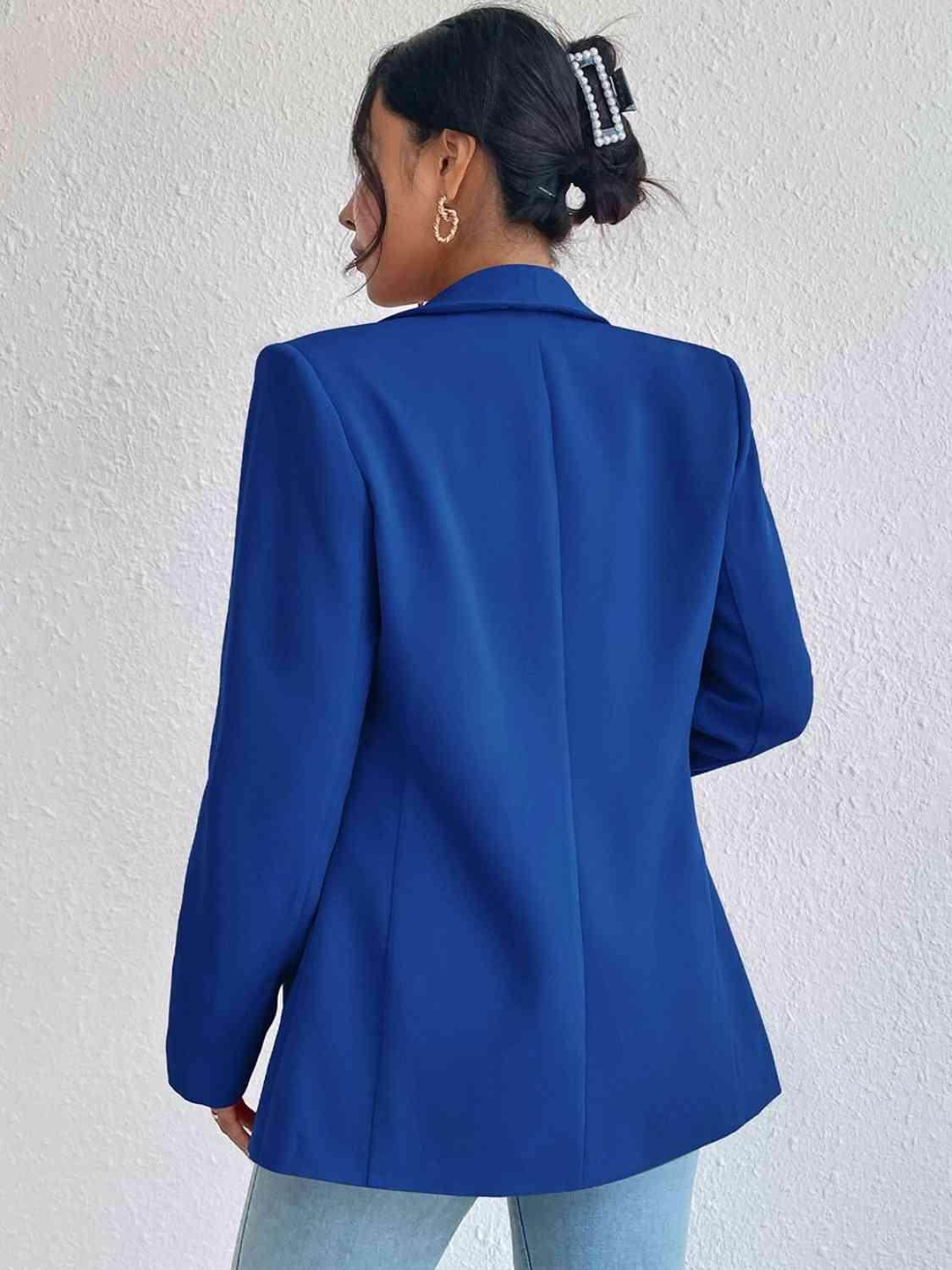 a woman wearing a blue blazer and jeans