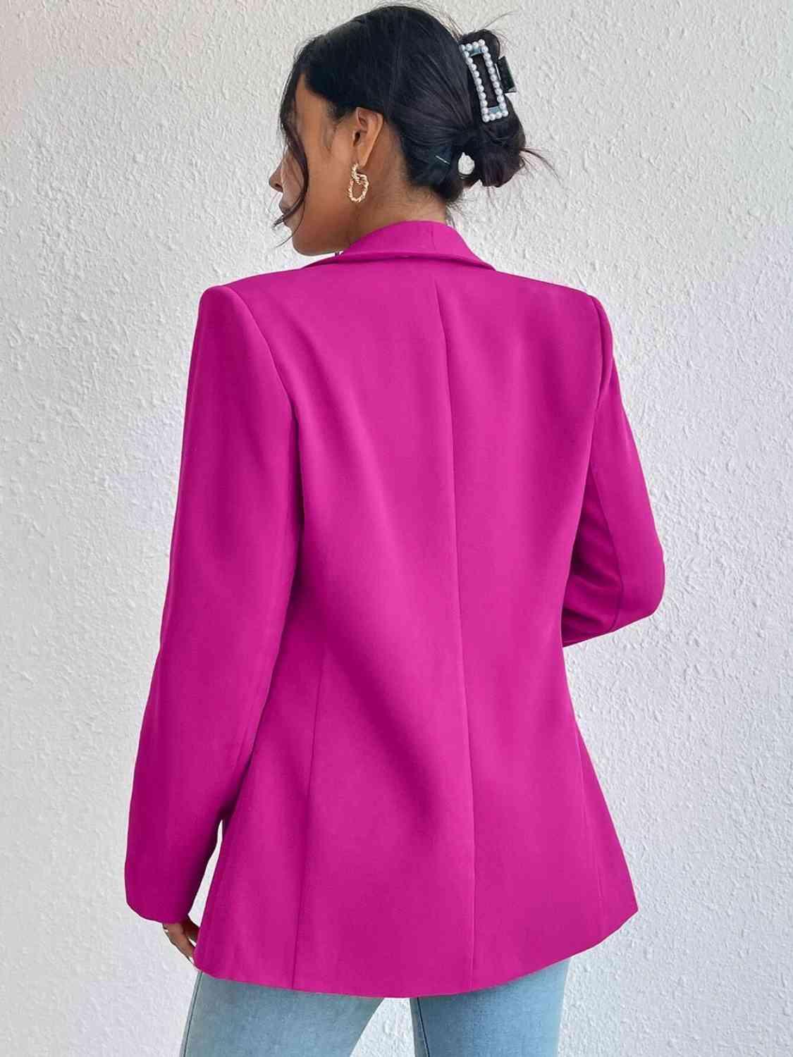 a woman wearing a bright pink blazer and jeans