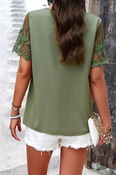 a woman wearing a green blouse and white shorts