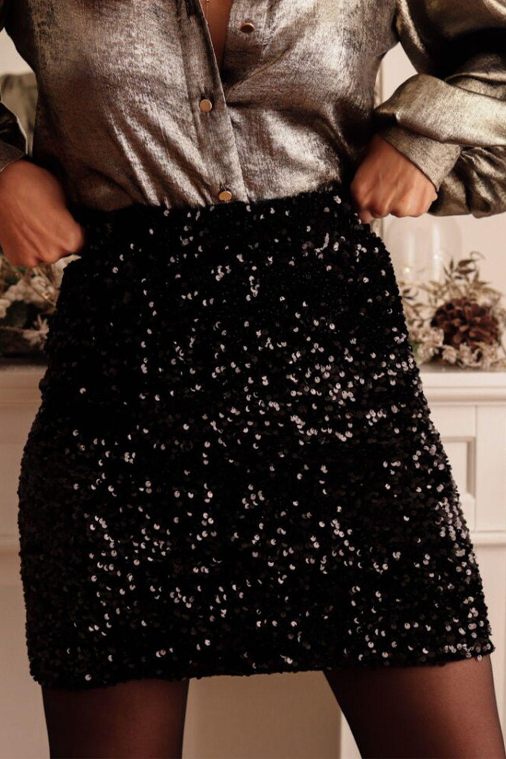 a woman in a metallic shirt and black sequin skirt