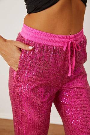 a close up of a person wearing pink sequin pants