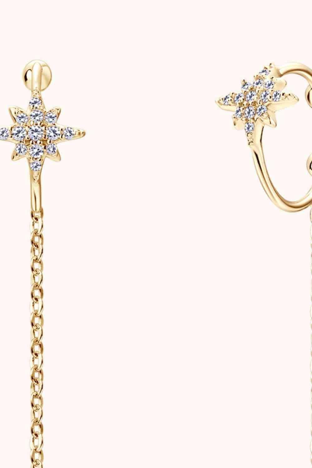 a pair of earrings with a cross and chain