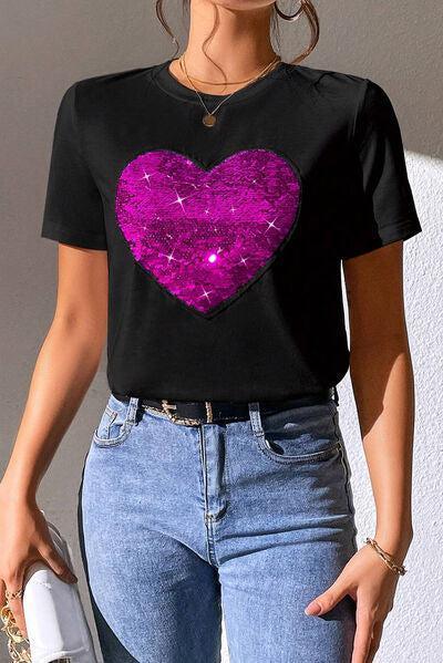 a woman wearing a black shirt with a pink heart on it