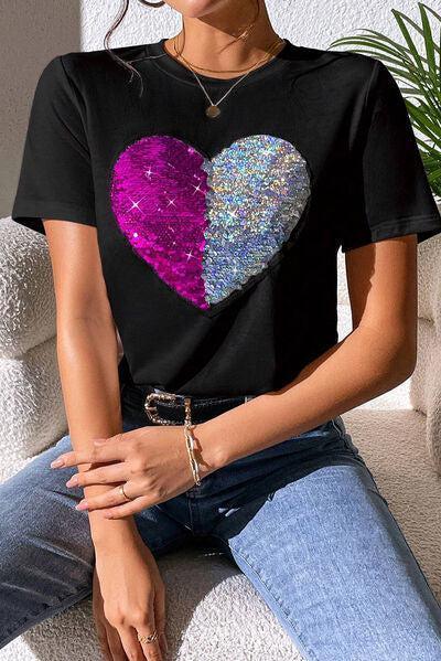 a woman sitting on a couch wearing a t - shirt with a heart on it