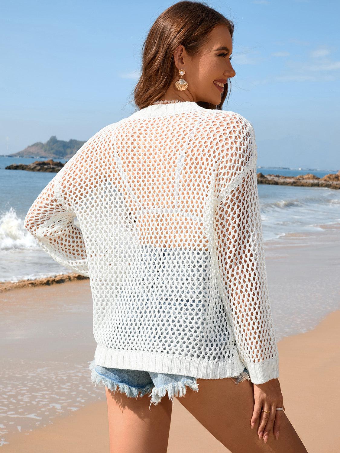 a woman standing on a beach next to the ocean