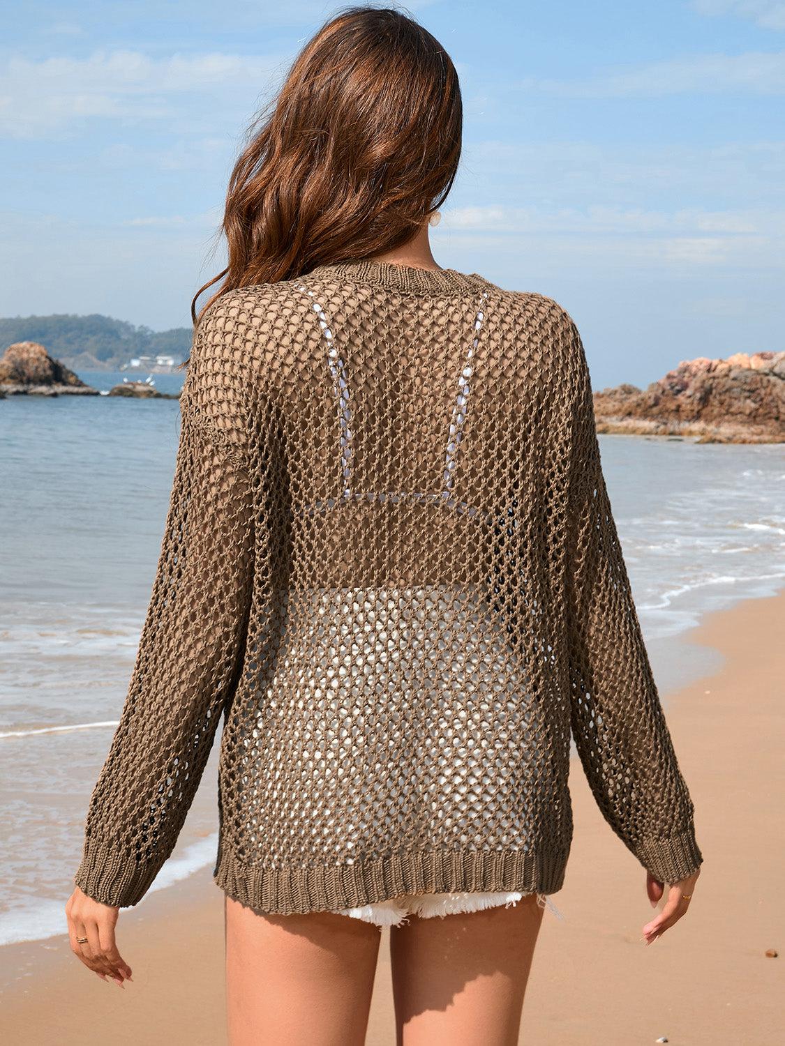 a woman walking along a beach next to the ocean