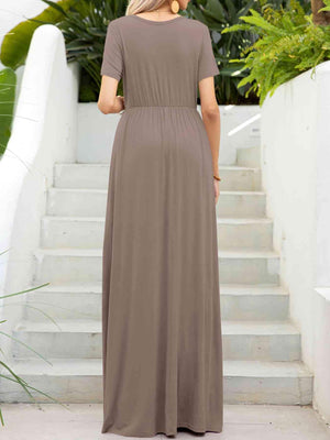 a woman wearing a brown dress standing in front of stairs