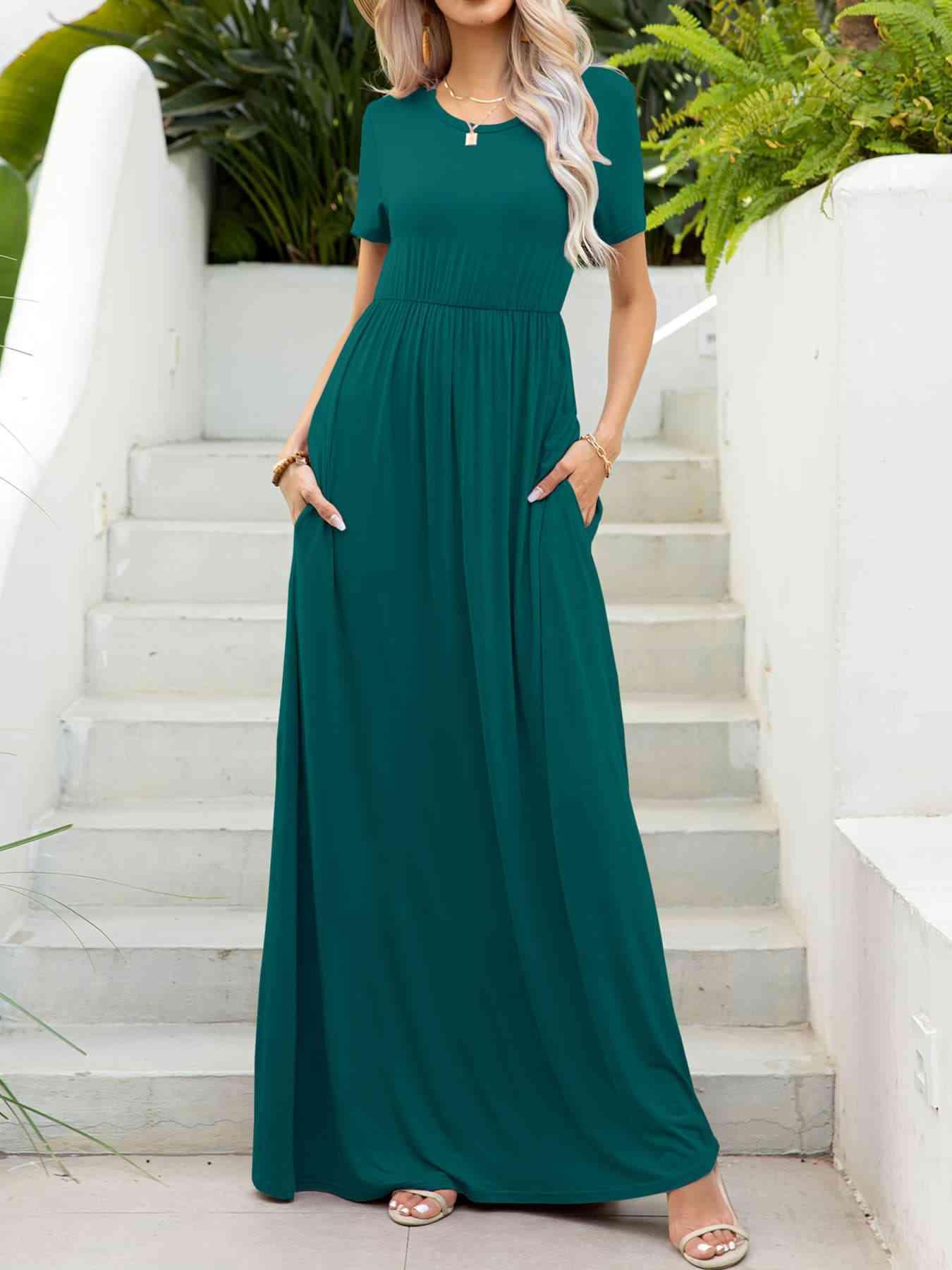 a woman wearing a green dress standing in front of stairs