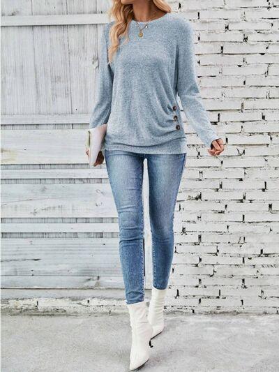 a woman wearing a gray sweater and jeans