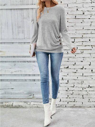 a woman standing in front of a white brick wall