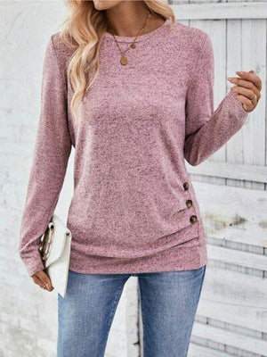 a woman wearing a pink sweater and jeans