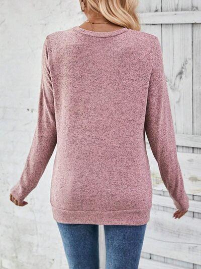 a woman wearing a pink sweater and jeans