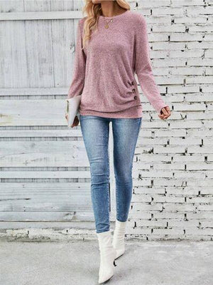 a woman wearing a pink sweater and jeans