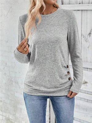 a woman wearing a grey sweater and jeans