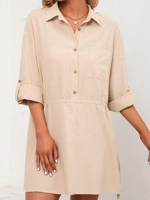 a woman wearing a beige shirt dress