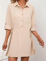 a woman wearing a beige shirt dress