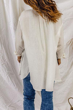 a woman standing in front of a white backdrop