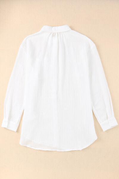 a women's white shirt is hanging on a wall