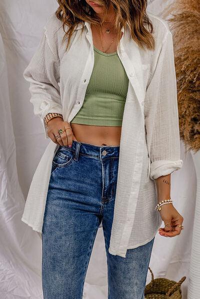 a woman wearing a white jacket and jeans