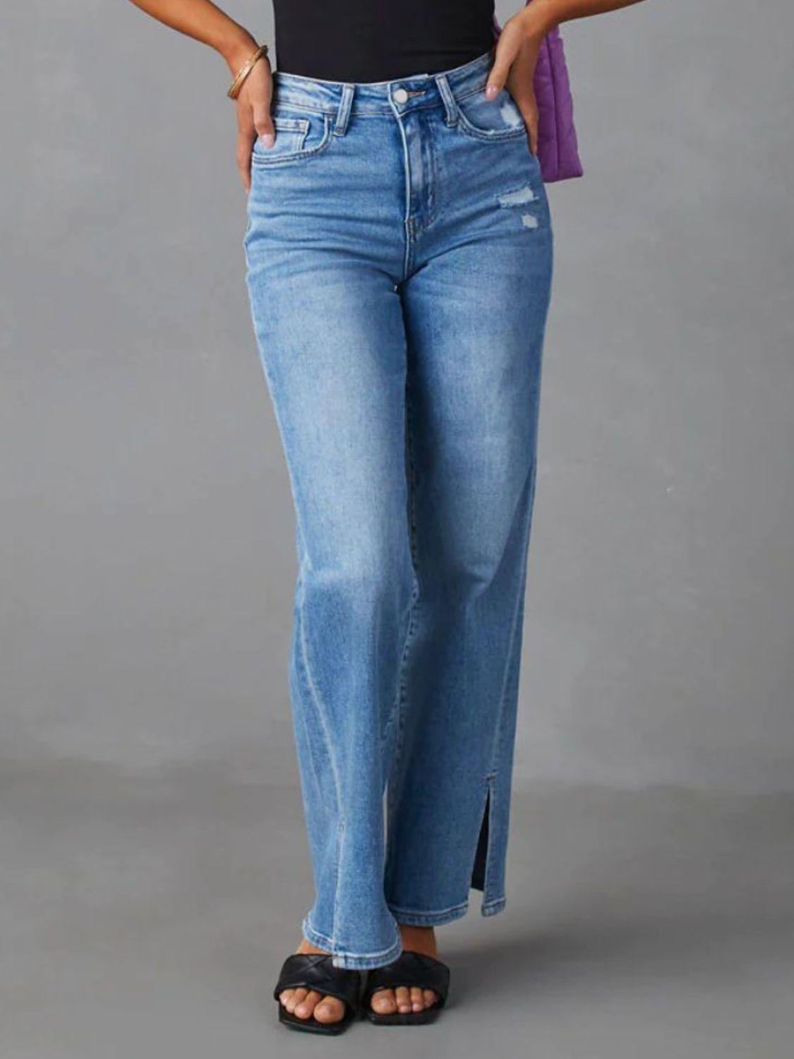 a woman in a black tank top and blue jeans