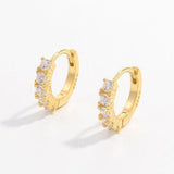 a pair of gold hoop earrings with small white stones