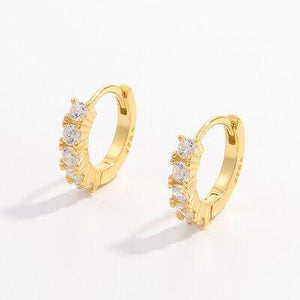 a pair of gold hoop earrings with small white stones