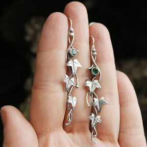 a person holding a pair of earrings in their hand