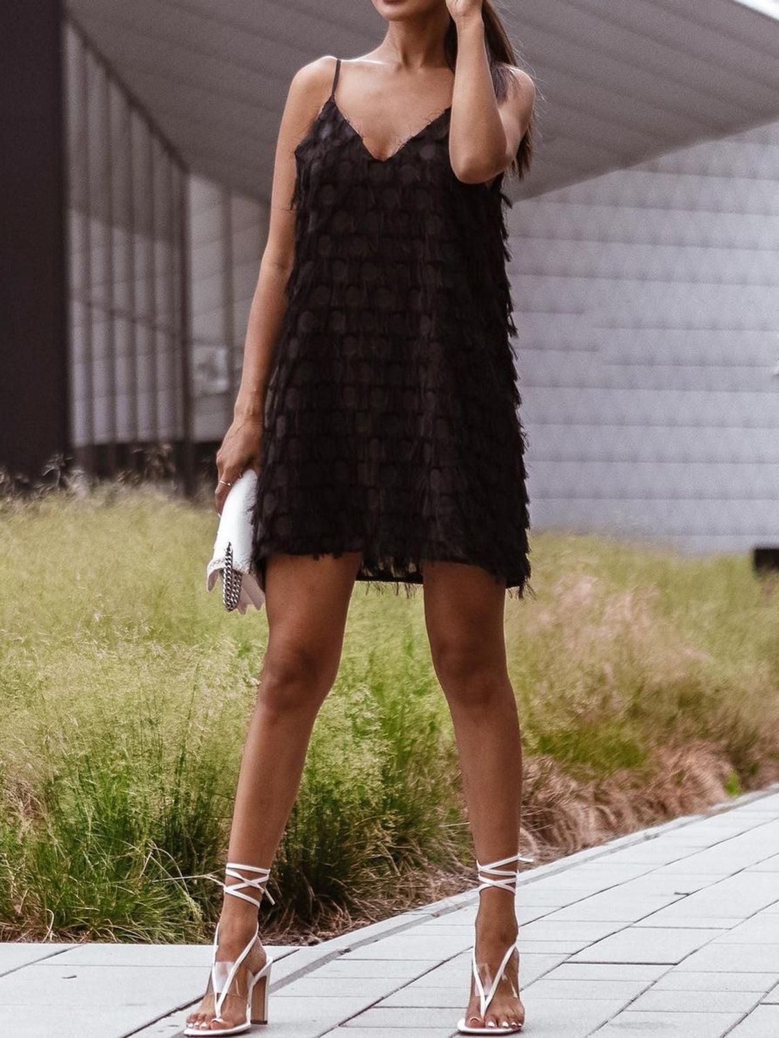 a woman in a black dress talking on a cell phone