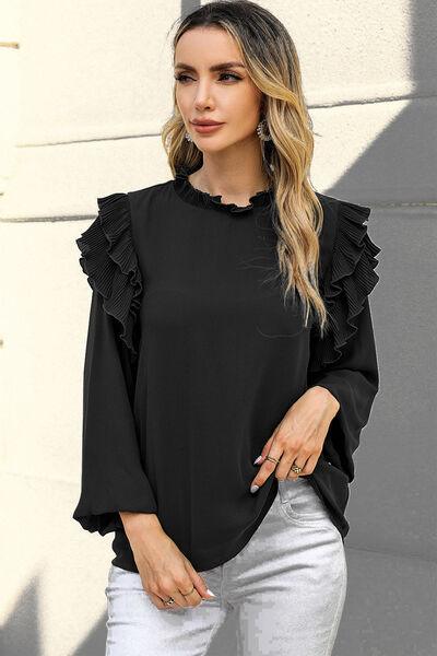 a woman wearing a black top with ruffled sleeves