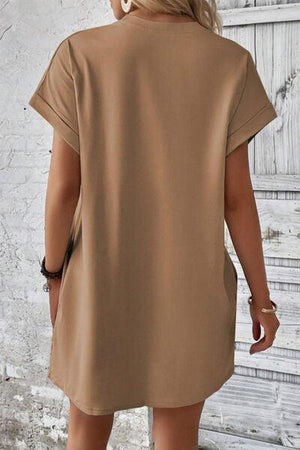 a woman wearing a tan shirt dress