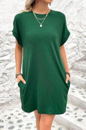 a woman wearing a green shirt dress