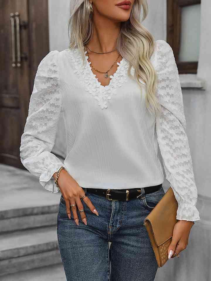 a woman wearing a white blouse and jeans