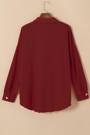 a red shirt hanging on a hanger