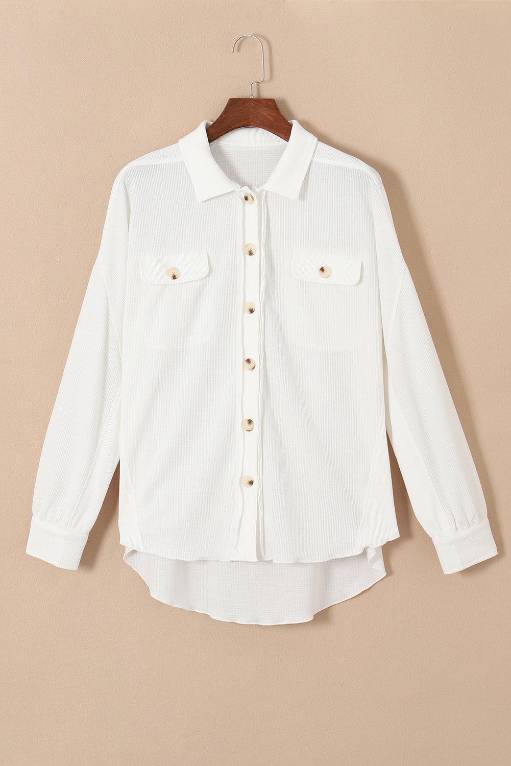a white shirt hanging on a wooden hanger