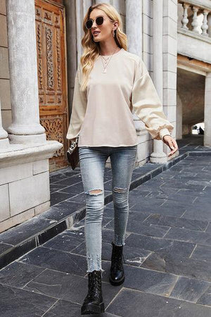 a woman walking down a street in ripped jeans