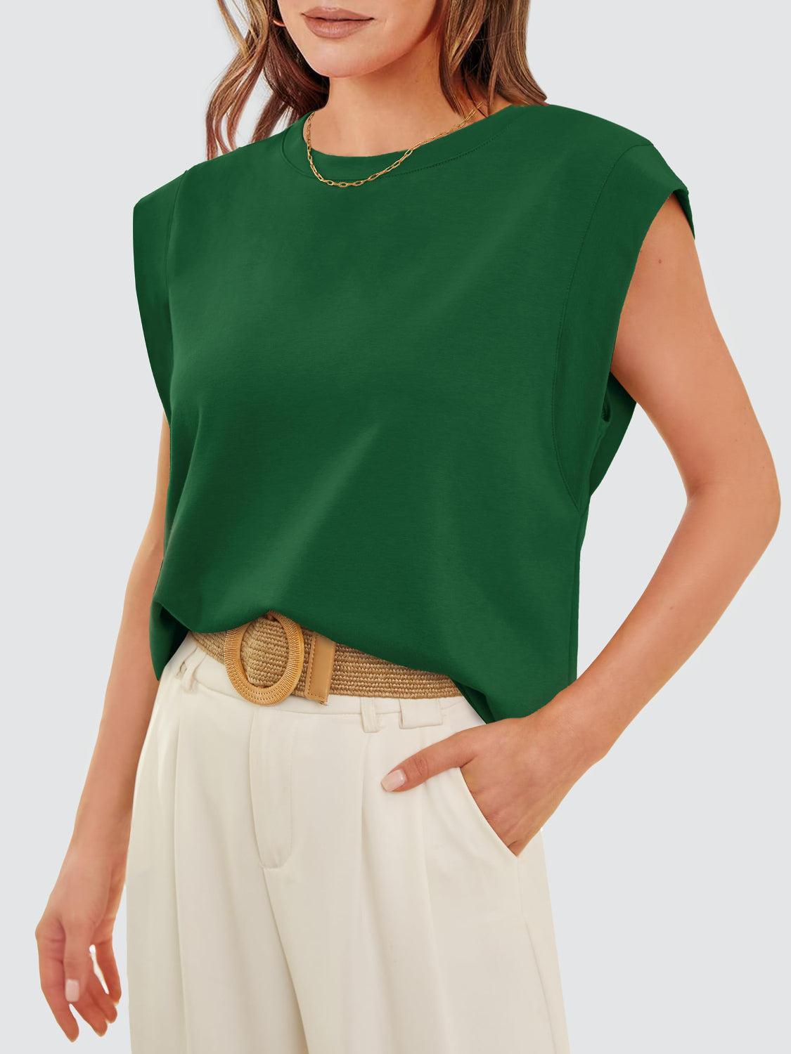 a woman wearing a green top and white pants