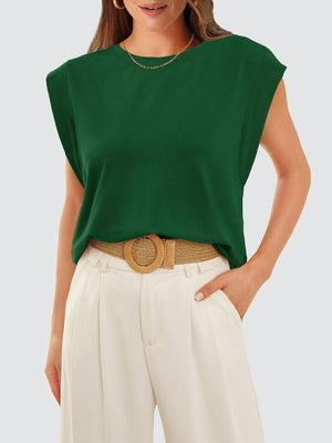 a woman wearing a green top and white pants