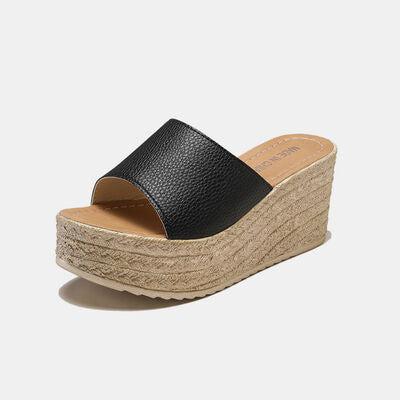 a woman's black wedged sandal with a platform