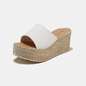 a woman's white wedged sandal with an open toe