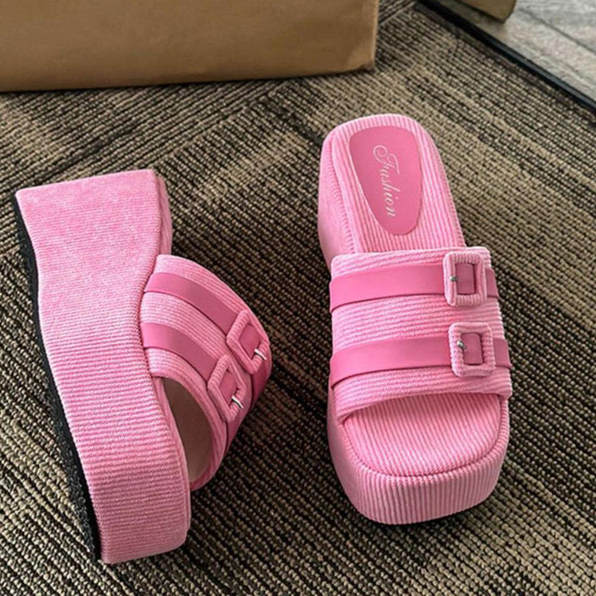 a pair of pink shoes sitting on top of a carpet