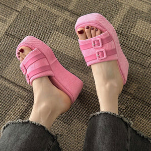 a person wearing pink sandals and black pants