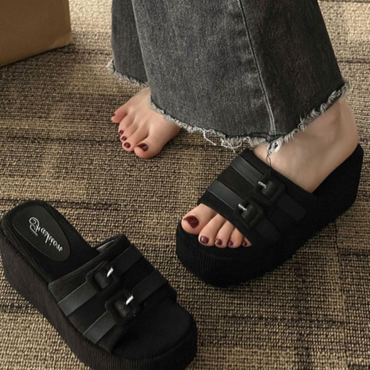 a person wearing black sandals and a pair of black sandals