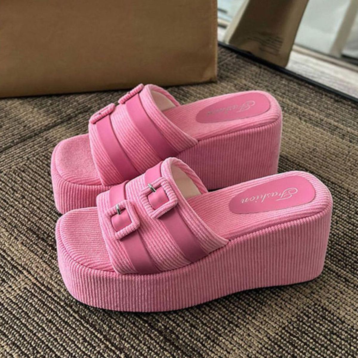 a pair of pink shoes sitting on top of a carpet