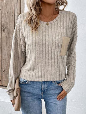 a woman wearing a beige sweater and jeans