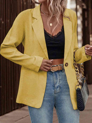 a woman wearing a yellow blazer and jeans