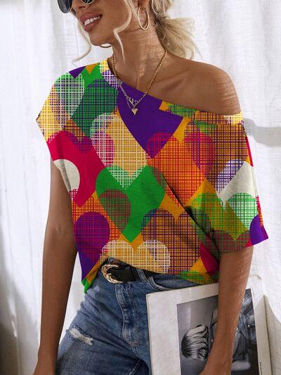 a woman wearing a colorful top and jeans