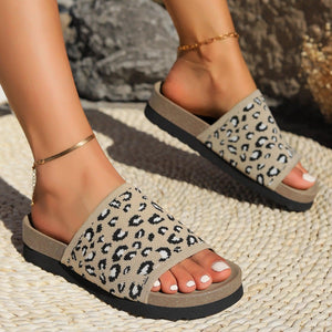 a close up of a person's feet wearing leopard print sandals