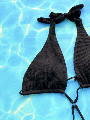 a bikini top laying on top of a swimming pool