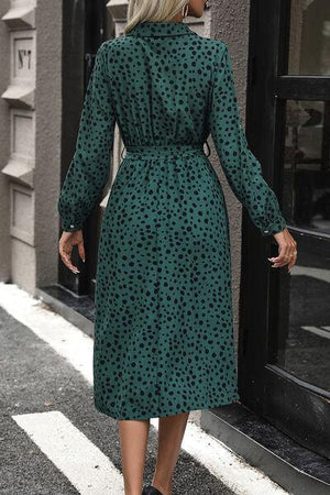 a woman in a green dress walking down the street