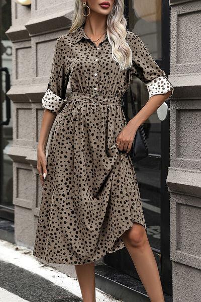 a woman standing on a sidewalk wearing a dress